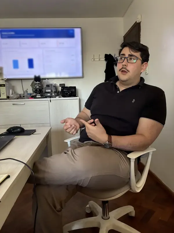 Alguien de Stratio conversa sentado en una oficina, con un tablero en la pantalla de atrás