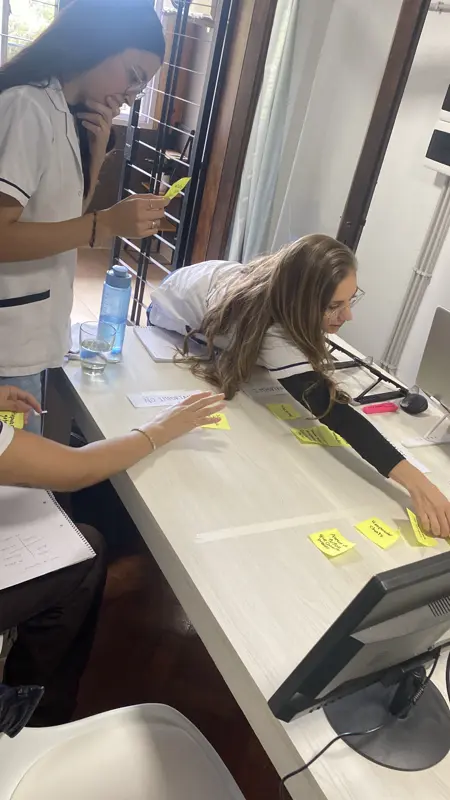 Un taller con el equipo de un cliente, ordenando tareas en post-its sobre la mesa