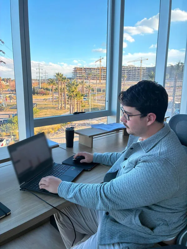 Alguien del equipo trabaja en su notebook junto a un ventanal